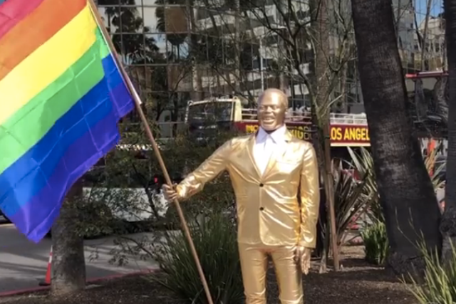 A statue resembling comedian Kevin Hart holding a rainbow flag appears near Oscars venue.