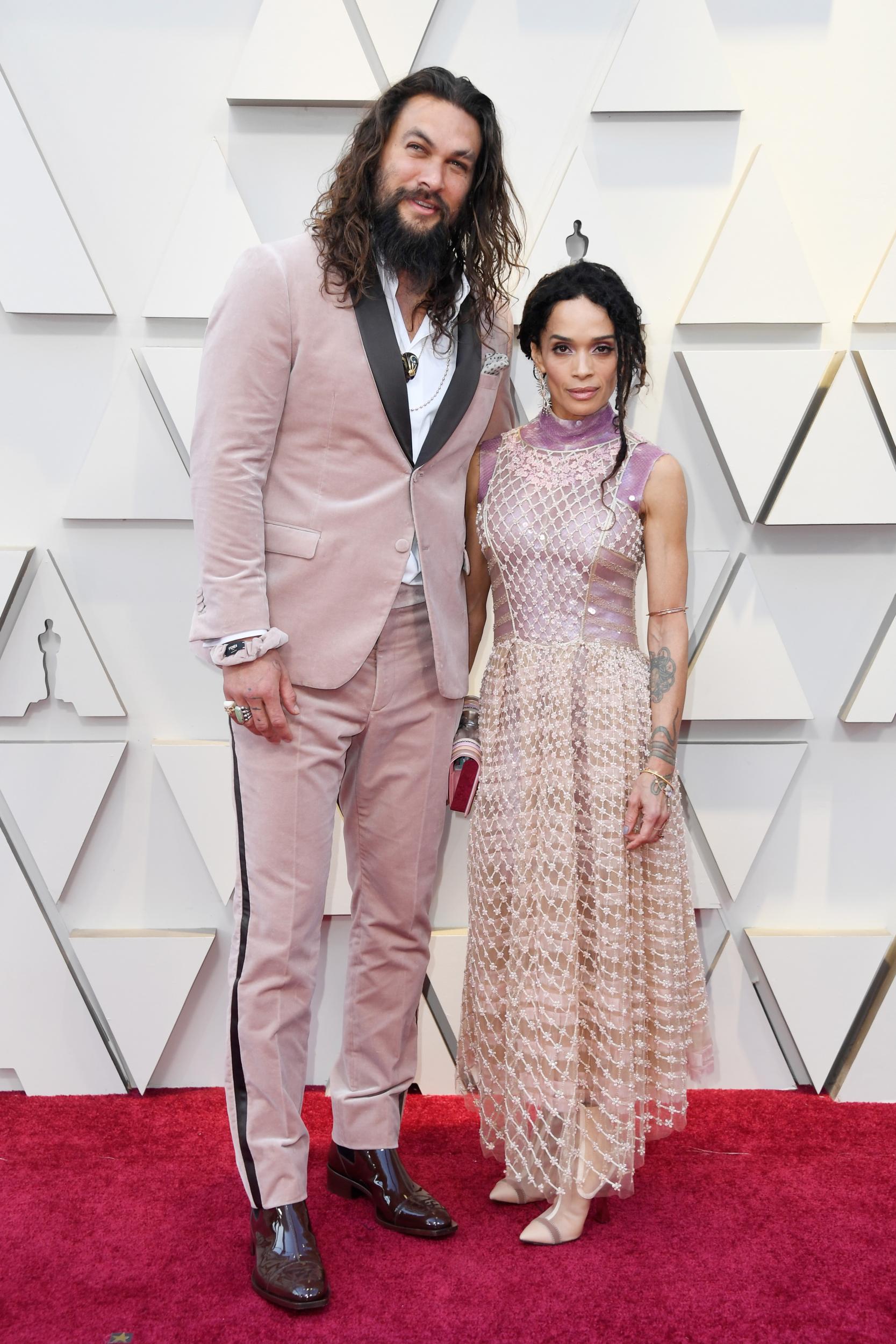 Jason Momoa and Lisa Bonet wear matching pink Karl Lagerfeld-designed outfits to the 2019 Oscars.