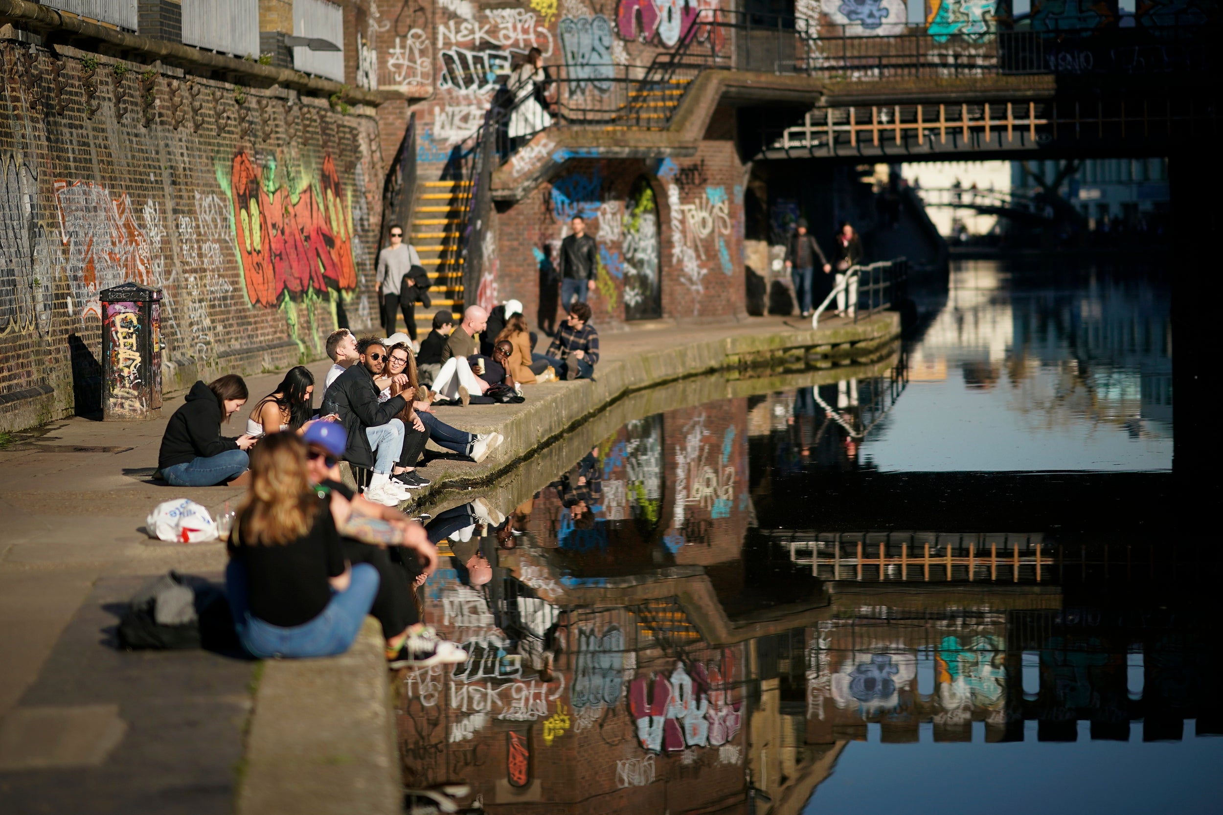 People enjoy the afternoon sunshine in alongside Regent's Canal, London