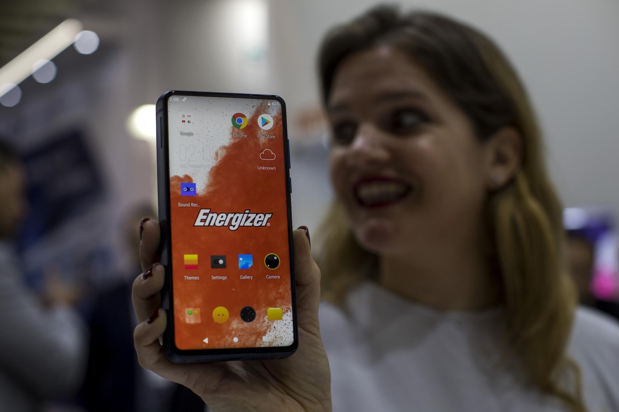 A worker holds a new model of P18K POP Energizer phone, with 18,000mAh battery, at the Mobile World Congress wireless show, in Barcelona, Spain