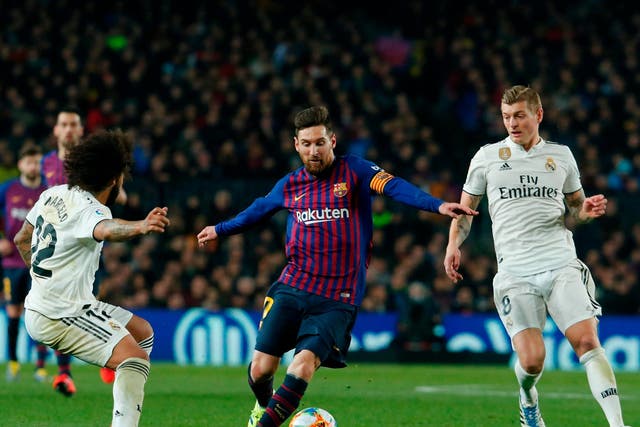 Barcelona's Lionel Messi vies for the ball with Real Madrid's Marcelo and Real Madrid's Toni Kroos