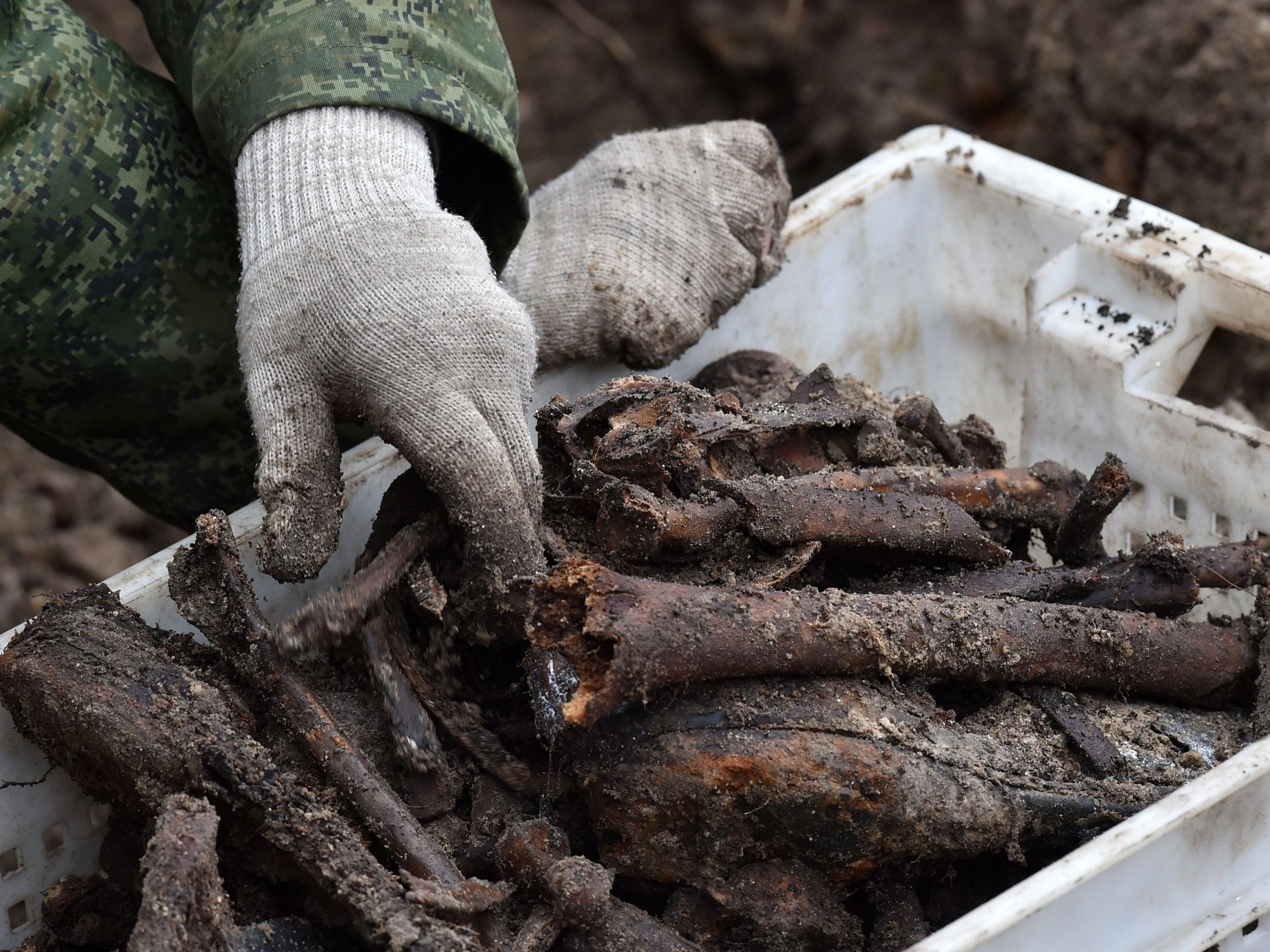 Belarus' servicemen excavate a mass grave at a construction site in the city of Brest