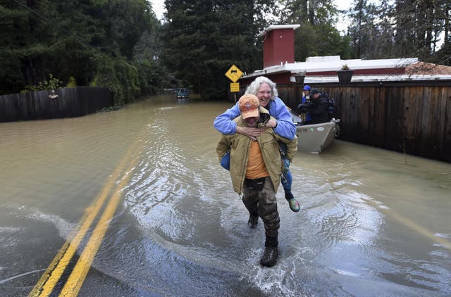 Bruce MacDonell carries his neighbor, Annie Lovell, through a flooded area of Guerneville, California on Friday, 15 February, 2019. Streets and low-lying areas flooded as the Russian River swelled above it's banks.