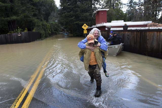 Bruce MacDonell carries his neighbor, Annie Lovell, through a flooded area of Guerneville, California on Friday, 15 February, 2019. Streets and low-lying areas flooded as the Russian River swelled above it's banks.