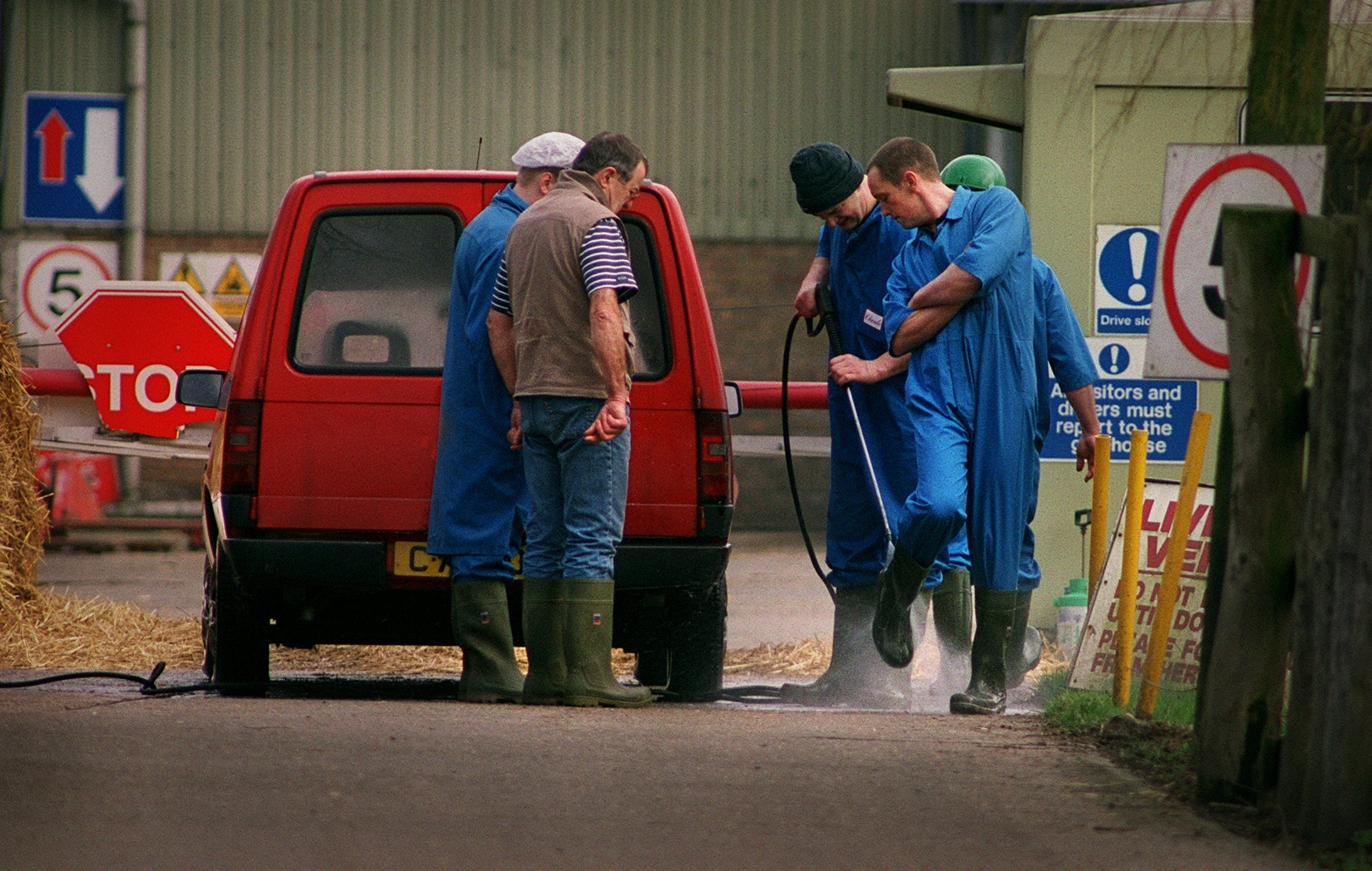 Cheale Meats workers disinfect their boots after leaving their facility in Brentwood, Essex