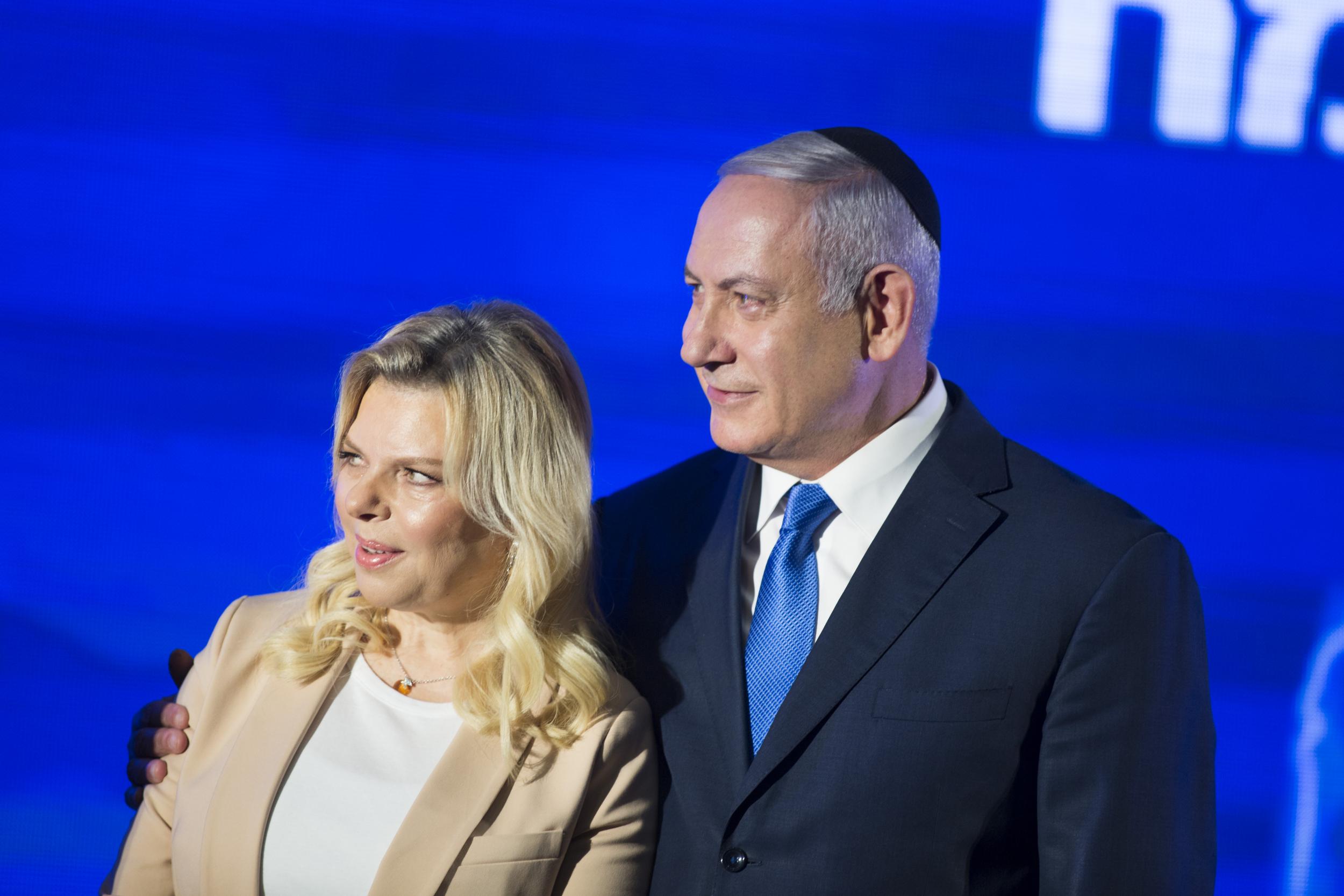 Benjamin Netanyahu stands by his wife Sara on the day Israel Securities Authority recommended indicting them both on bribery and other corruption charges