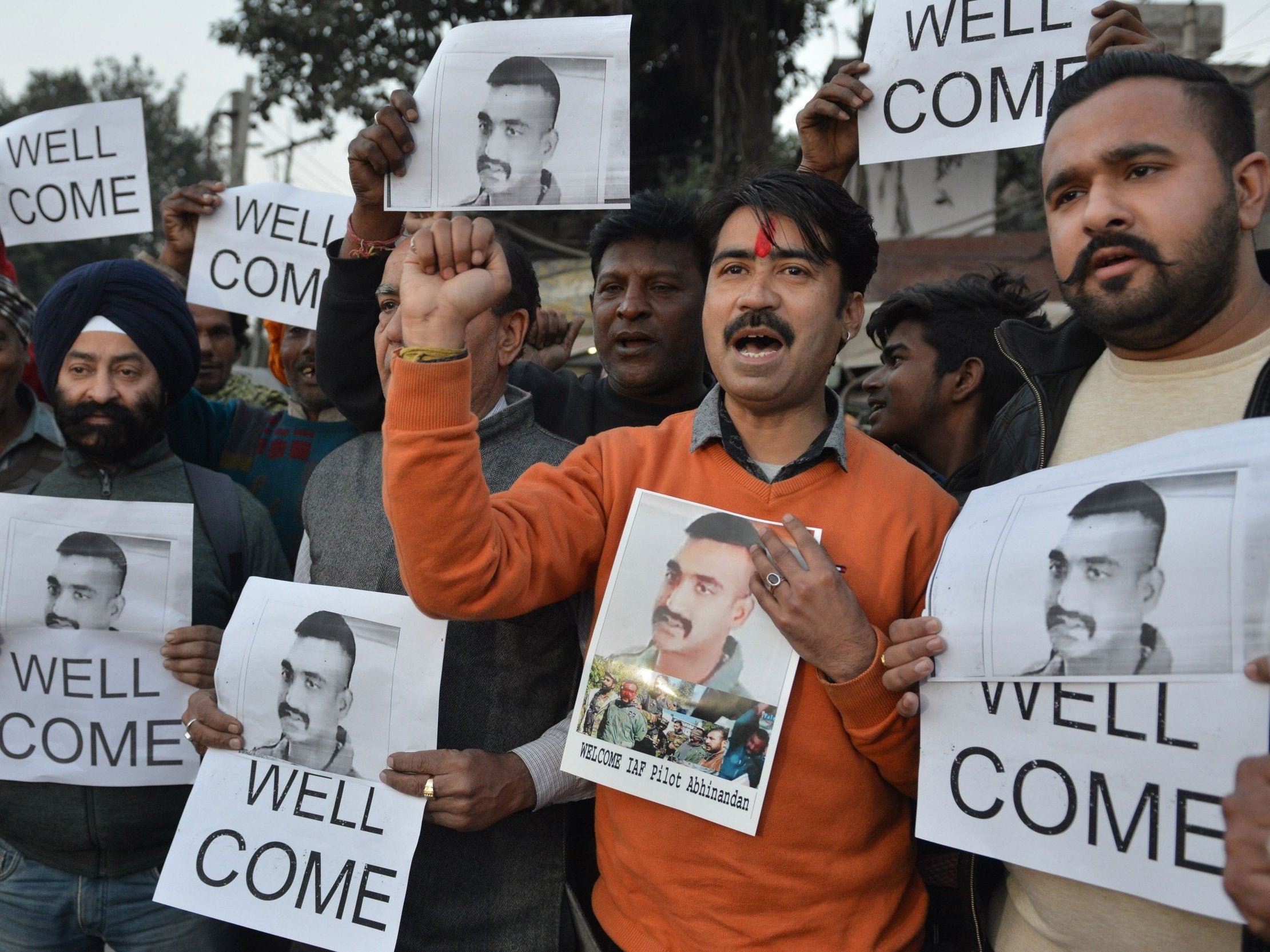 People hold photographs of the Indian air force pilot yesterday as they celebrate his release