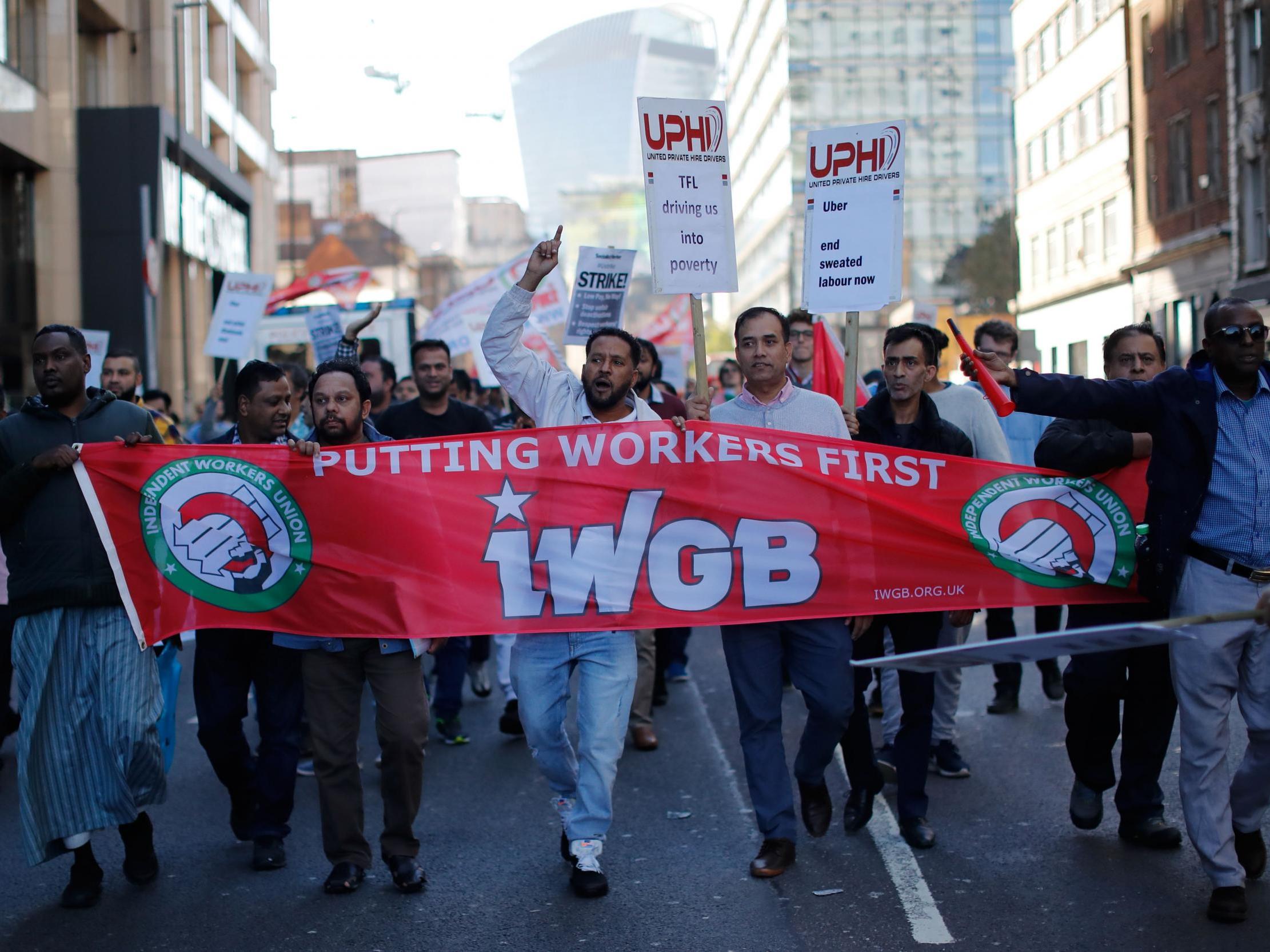 Drivers march in London with placards and banners from the IWGB