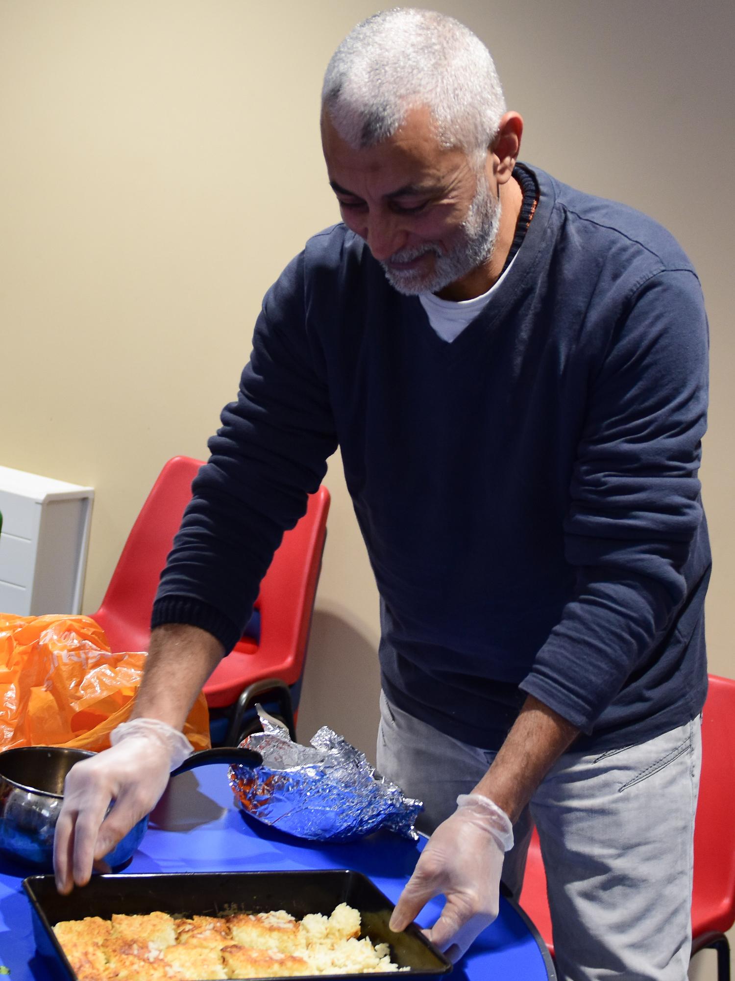 Osman preparing food for a Migrateful cookery class, where asylum-seekers are teachers