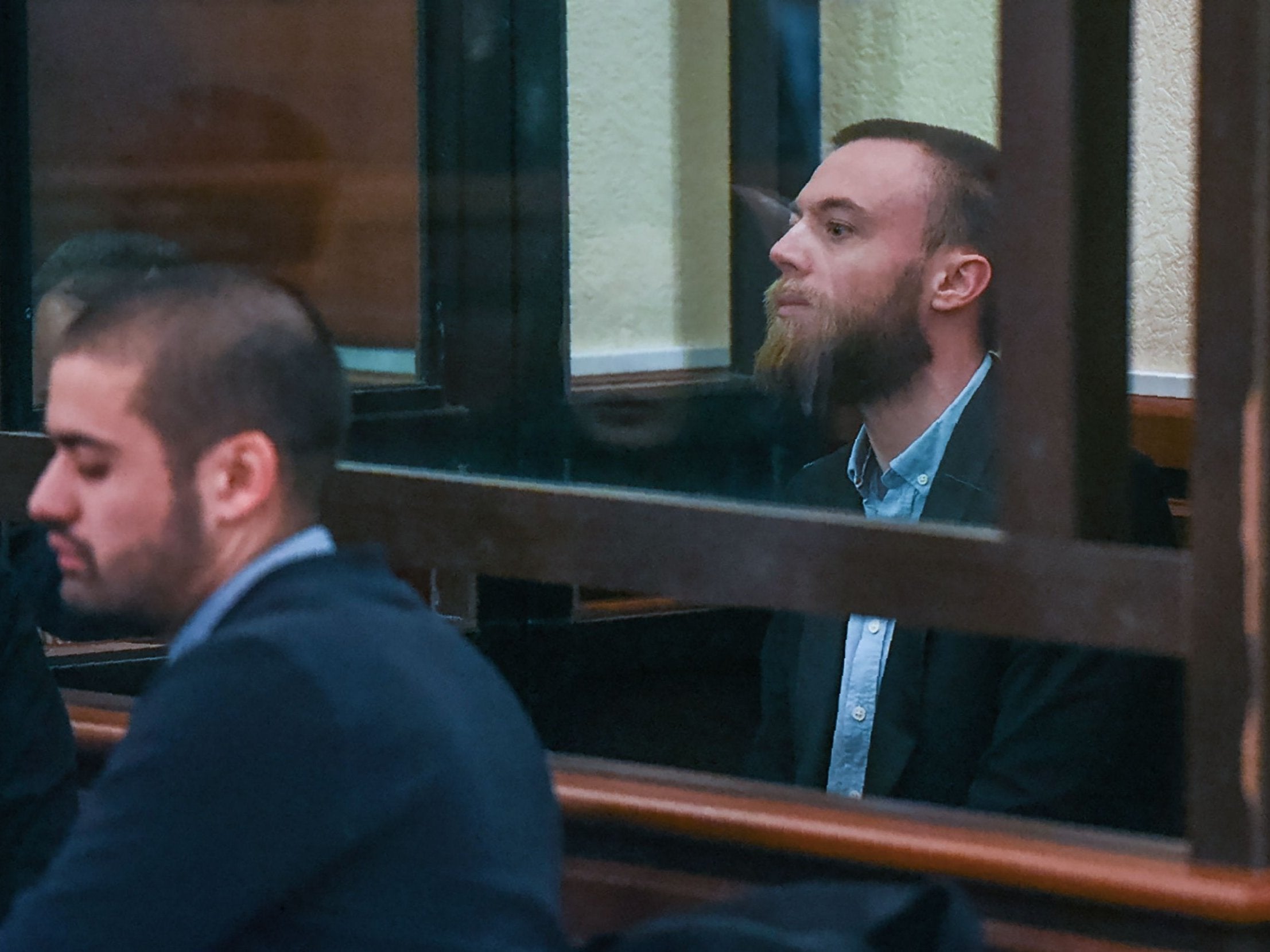 Jack Shepherd sits inside a defendants’ cage during an extradition hearing at a court in Tbilisi, Georgia in January 2019