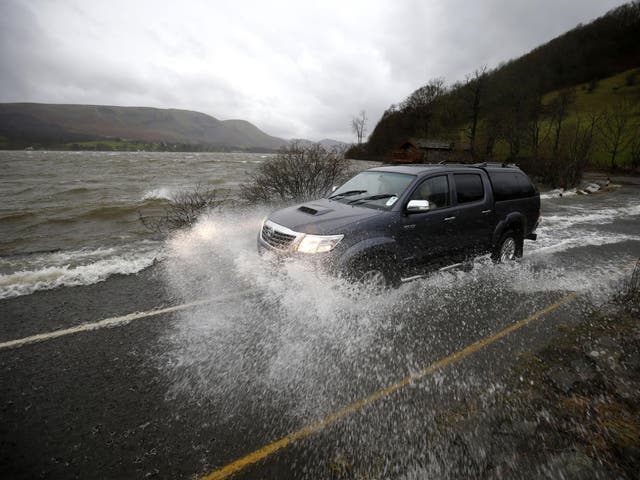 Water from Ullswater floods across a road in Cumbria following heavy rain