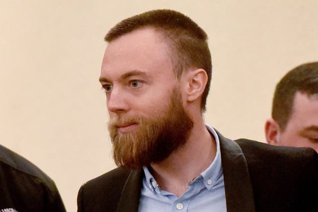 Jack Shepherd is escorted towards a defendants' cage ahead of a hearing at a court in Tbilisi