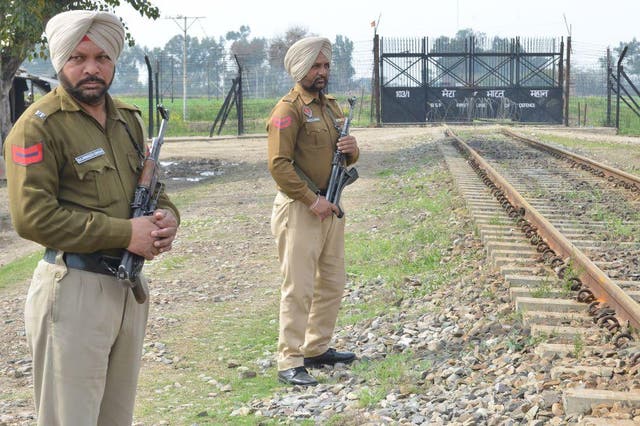 Indian Punjab Police personnel stand guard at the border fence gate near India-Pakistan border on the outskirts of Amritsar.
