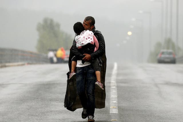 A Syrian refugee kisses his daughter approaching Greece’s border with Macedonia in 2015