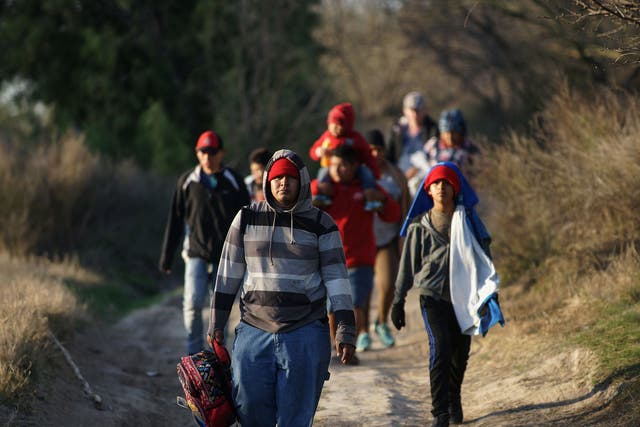 Central American migrants walk along the Mexican bank of the Rio Bravo that divides the cities of Eagle Pass, in Texas, US and Piedras Negras, in the state of Coahuila, Mexico on February 17, 2019. Debates over the US border wall are the newest issue to plague Hispanic immigrants hoping to live in the US