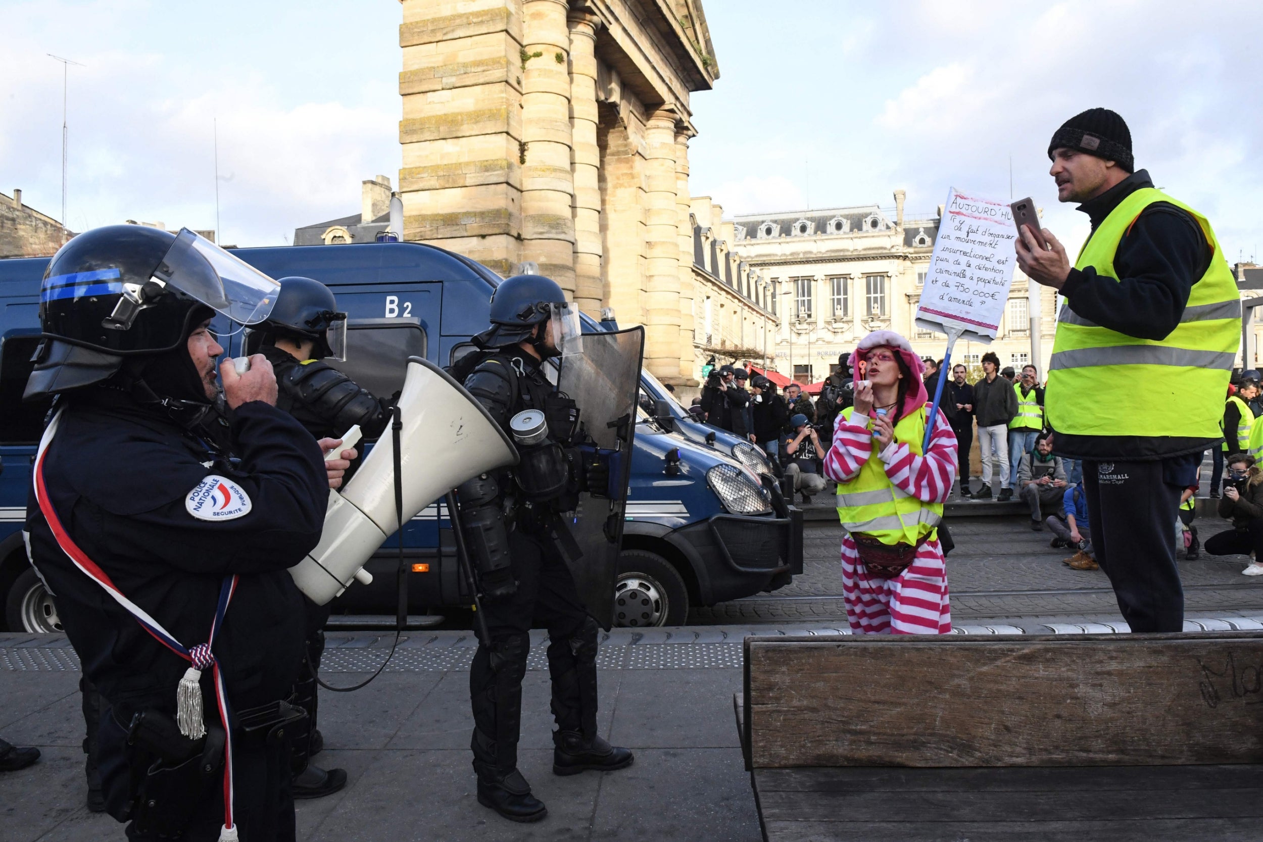 A yellow vest protester blows bubbles at police in southwestern France (AFP/Getty)