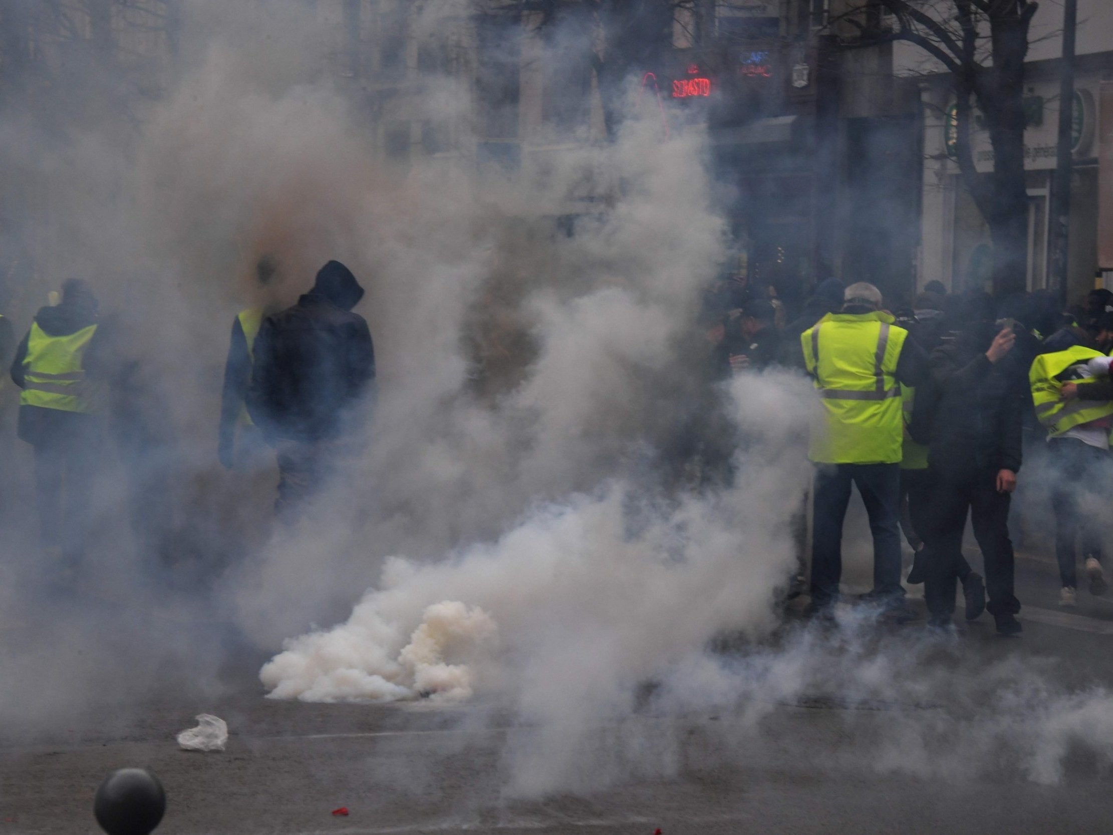 Protesters stand in tear gas smoke during a 'yellow vest' anti-government demonstration in Lille, on Saturday