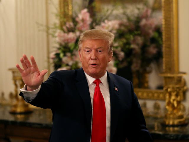 US President Donald Trump waves as he departs the room after delivering remarks to the National Association of Attorneys General in the State Dining Room at the White House in Washington