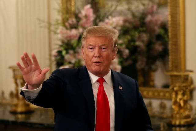 US President Donald Trump waves as he departs the room after delivering remarks to the National Association of Attorneys General in the State Dining Room at the White House in Washington
