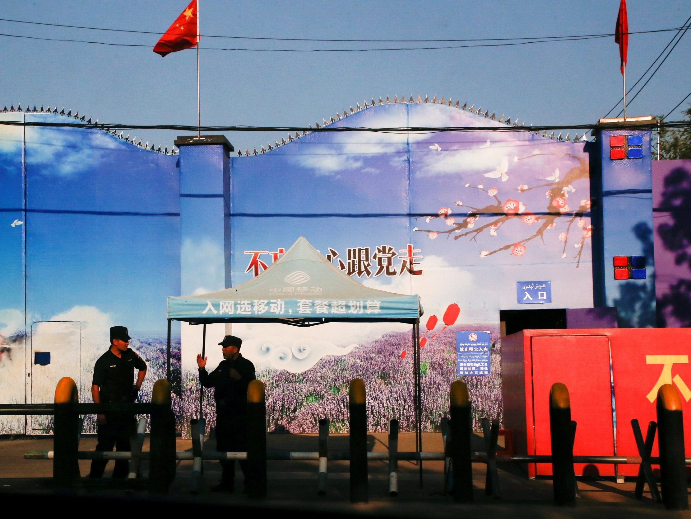 Security guards stand at the gates of what is officially known as a vocational skills education centre in Huocheng County in Xinjiang province