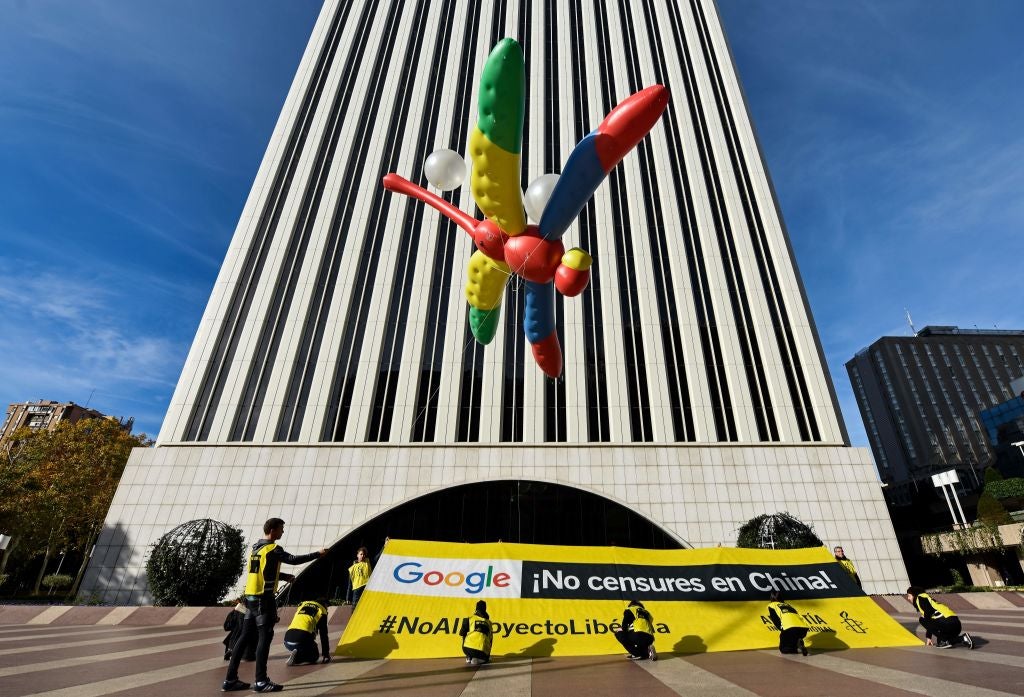 Amnesty International activists hold a giant dragonfly-shaped balloon with a banner reading 'Google, do not censor in China, no to the Dragonfly project' during a protest outside the Google headquarters in Madrid on 27 November, 2018