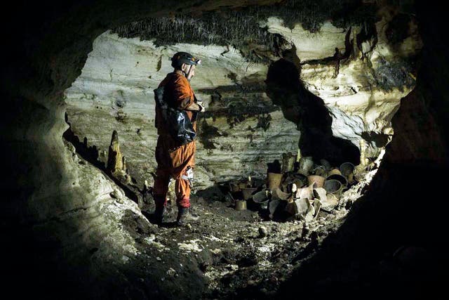 <p>An archaeologist stands next to pre-columbian artifacts in a cave at the Mayan ruins of Chichen Itza</p>