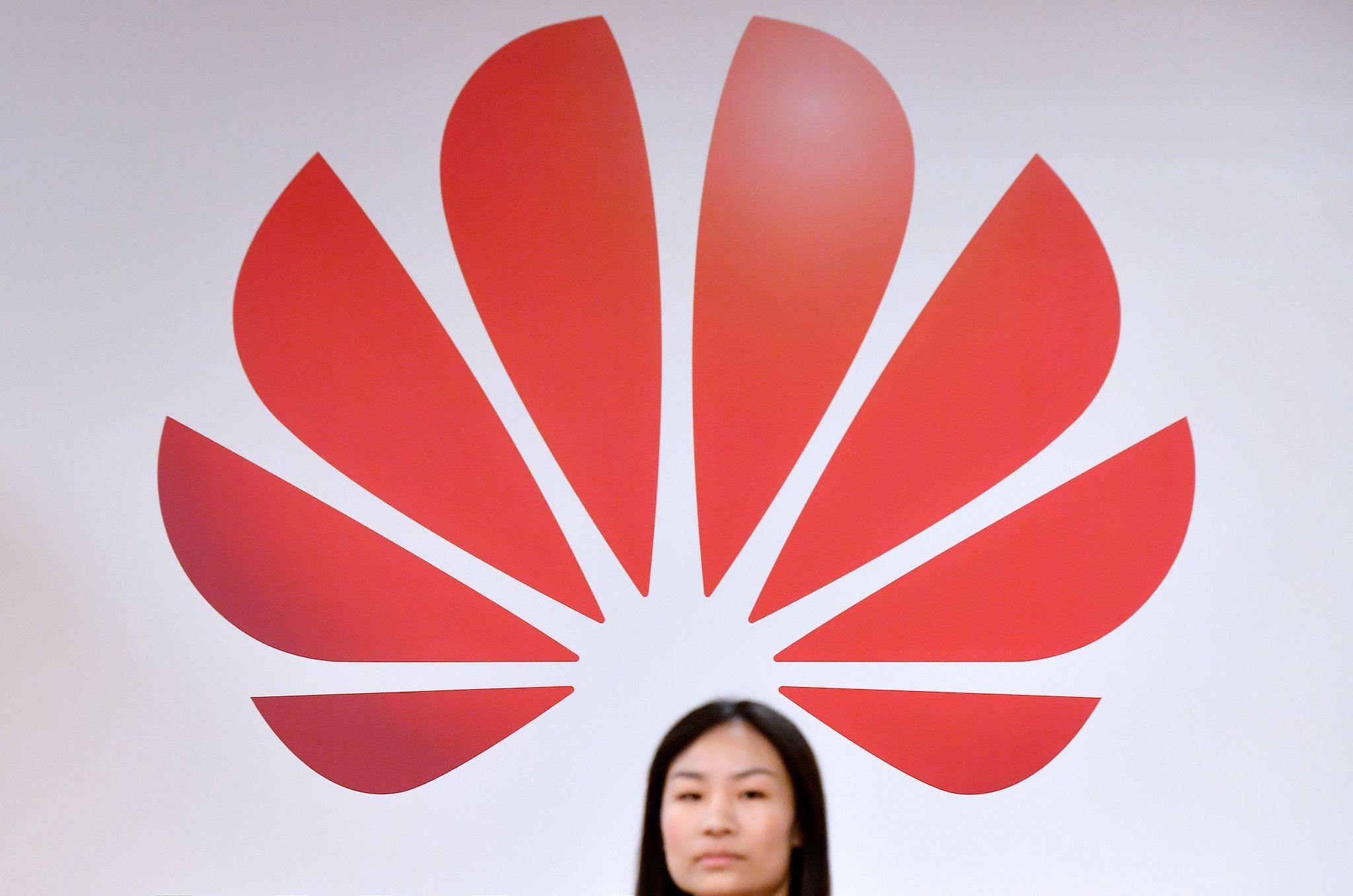 A woman walks past a logo at the entrance of the European Huawei Cyber Security Transparency Centre during its opening in Brussels on March 5, 2019
