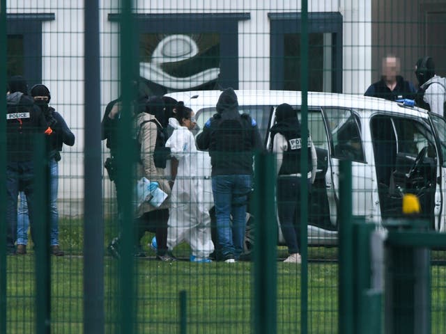 A handcuffed person is escorted by security forces from the penitentiary centre of Alencon, in Conde-sur-Sarthe, northwestern France, on 5 March 2019. An inmate was captured by armed police after stabbing two prison guards.