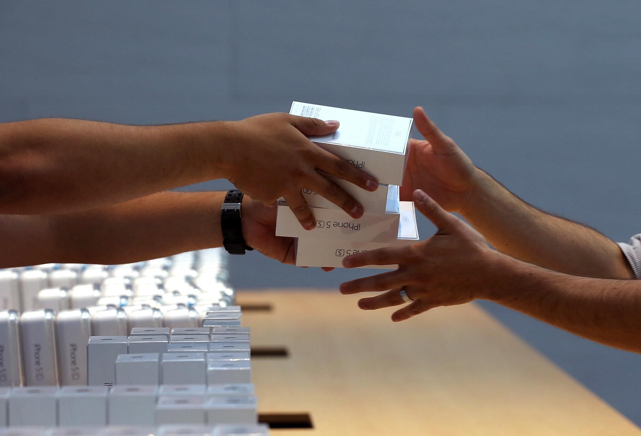 Apple Store employees pass boxes of the new Apple iPhone 5S on September 20, 2013 in Palo Alto, California