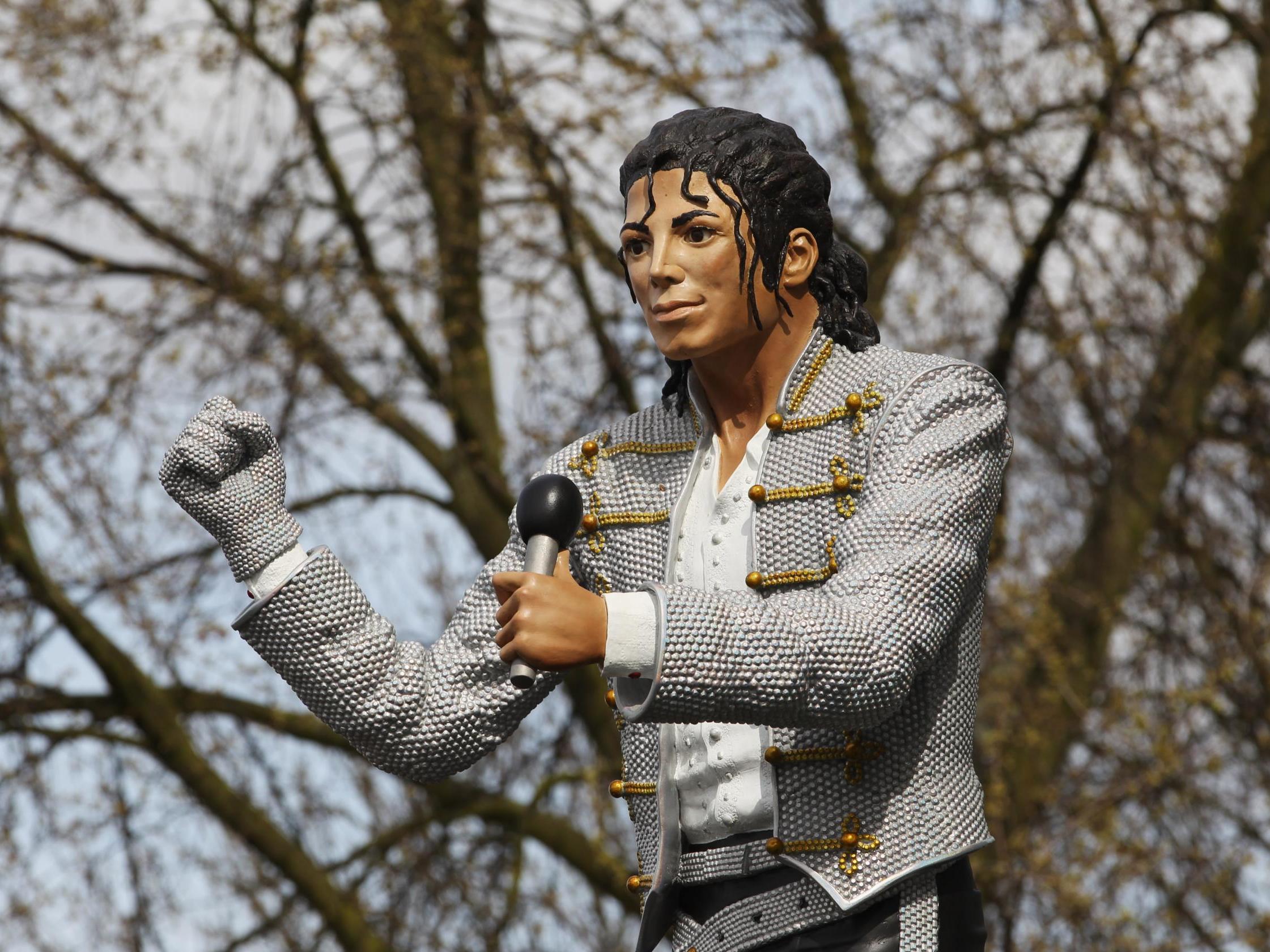 Former Fulham FC chairman Mohamed Al Fayed unveils a statue in tribute to Michael Jackson at the club's Craven Cottage stadium in April 2011.