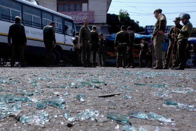 Indian police inspect the site of a grenade blast at a bus station in Jammu