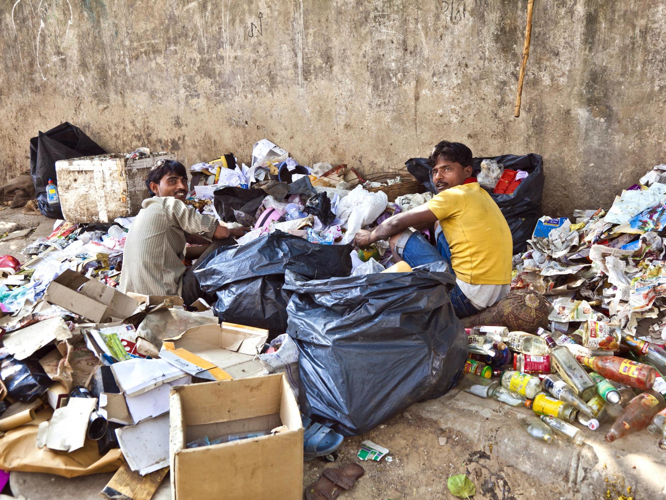 Workers checking rubbish for plastic and paper for waste separation in Delhi, India