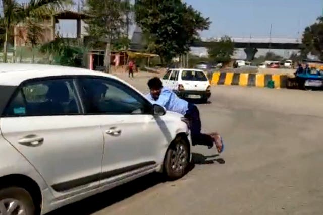 A driver was carried for more than a mile on the bonnet of a moving car in a road rage incident Ghaziabad, India