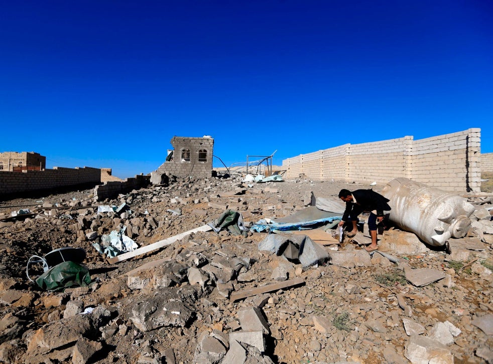 A man checks the debris of a building destroyed in Saudi-led air strikes in Yemen’s capital