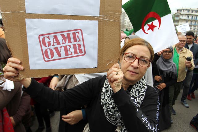 A woman holds a poster as she demonstrates in Algiers, Friday, March 8, 2019.