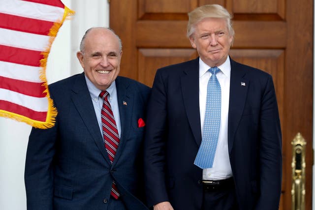 Pictured on 20 November 2016: Then-President-elect Donald Trump (right), and former New York Mayor Rudy Giuliani pose for photographs as Mr Giuliani arrives at the Trump National Golf Club Bedminster clubhouse in Bedminster.