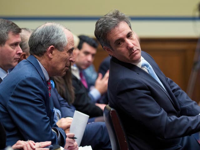 Michael Cohen, right, President Donald Trump's former lawyer, leans back to listen to his lawyer, Lanny Davis of Washington, as he testifies before the House Oversight and Reform Committee, on Capitol Hill, Wednesday in Washington.