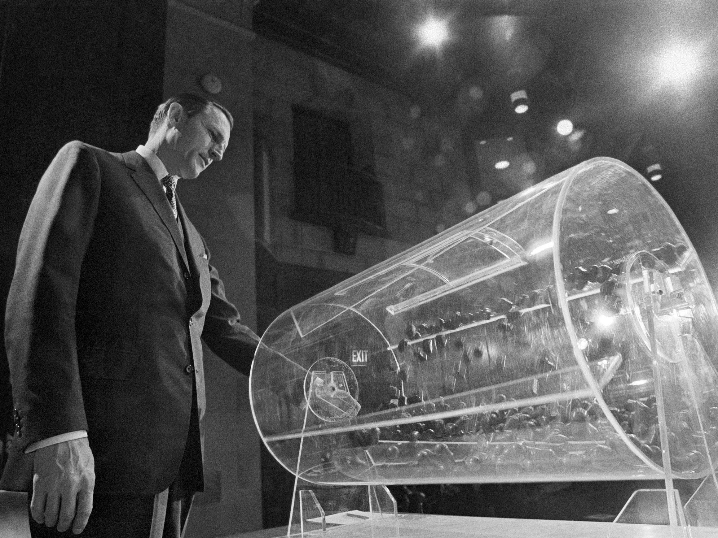 Pictured: Draft Director Curtis W. Tarr spins a Plexiglas drum in Washington as the 4th annual .lottery draw begins on 2 February 1972.