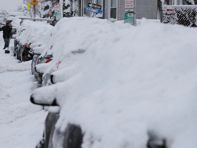 A driver shovels out his car following a winter snow storm in Somerville