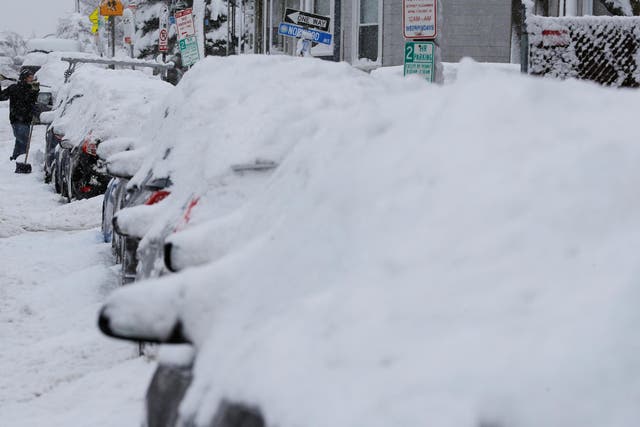 A driver shovels out his car following a winter snow storm in Somerville