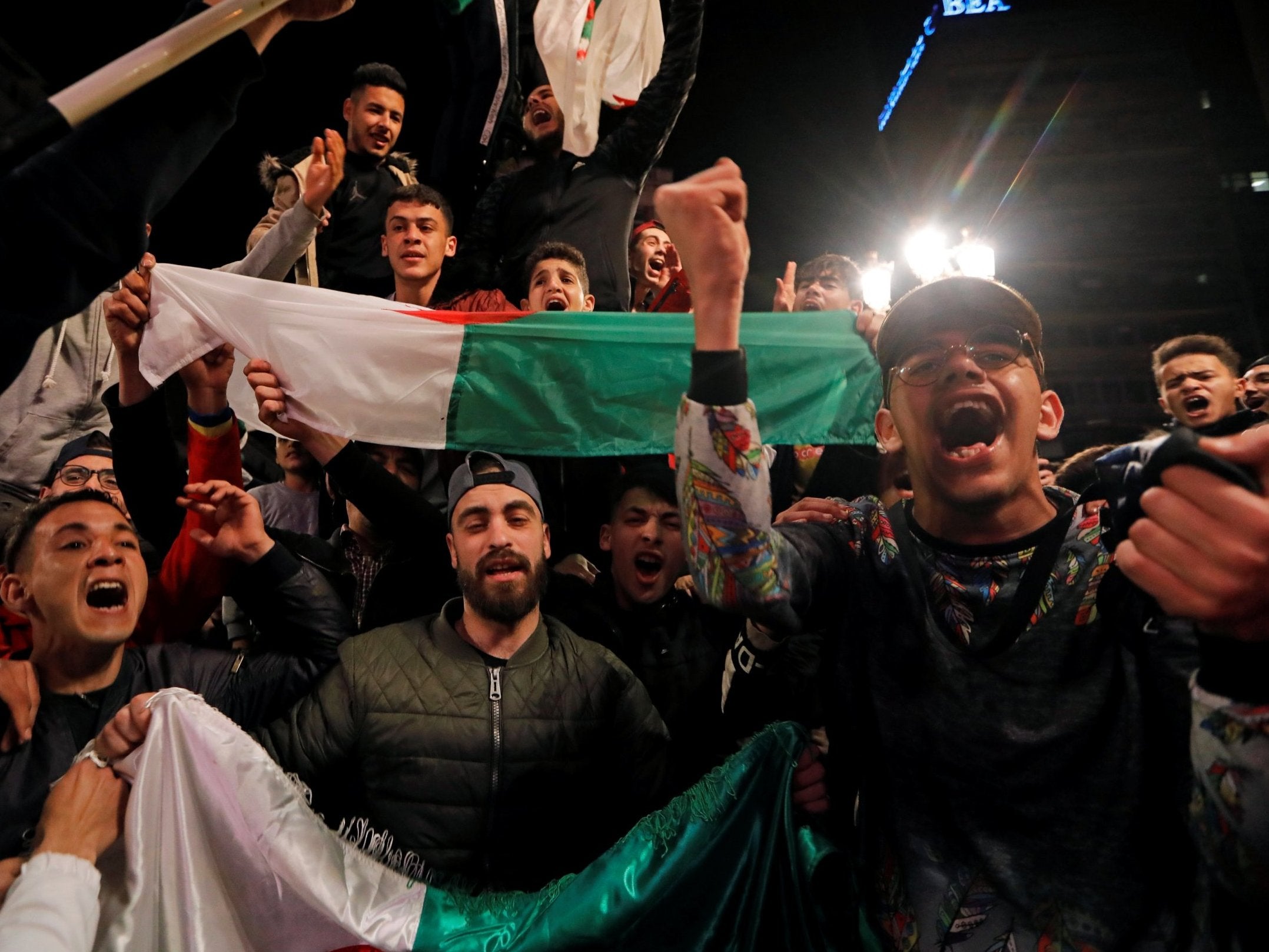 People celebrate on the streets after President Abdelaziz Bouteflika announced he will not run for a fifth term.