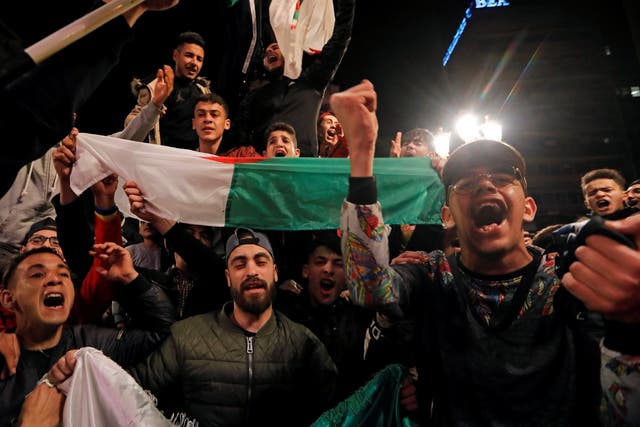 People celebrate on the streets after President Abdelaziz Bouteflika announced he will not run for a fifth term.
