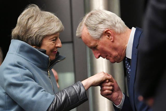 Michel Barnier greets Theresa May as she arrives at the European parliament on Monday