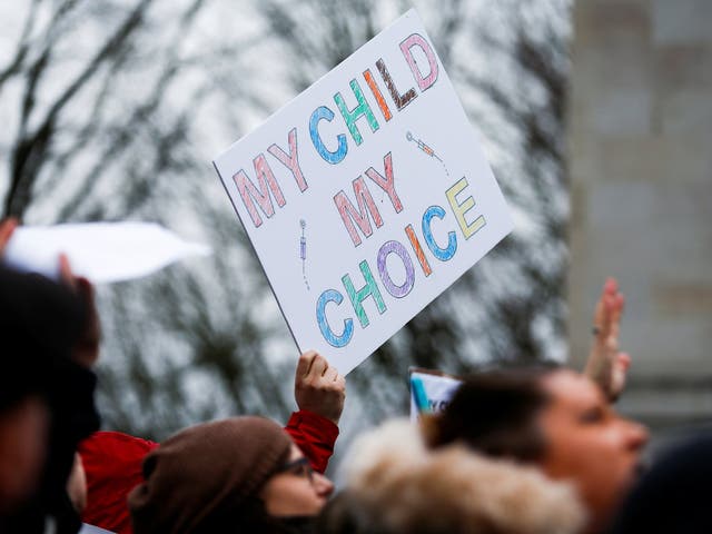 A protester holds a sign reading "My child, my choice" during a "March for Medical Freedom"