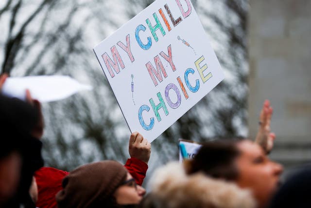 A protester holds a sign reading "My child, my choice" during a "March for Medical Freedom"