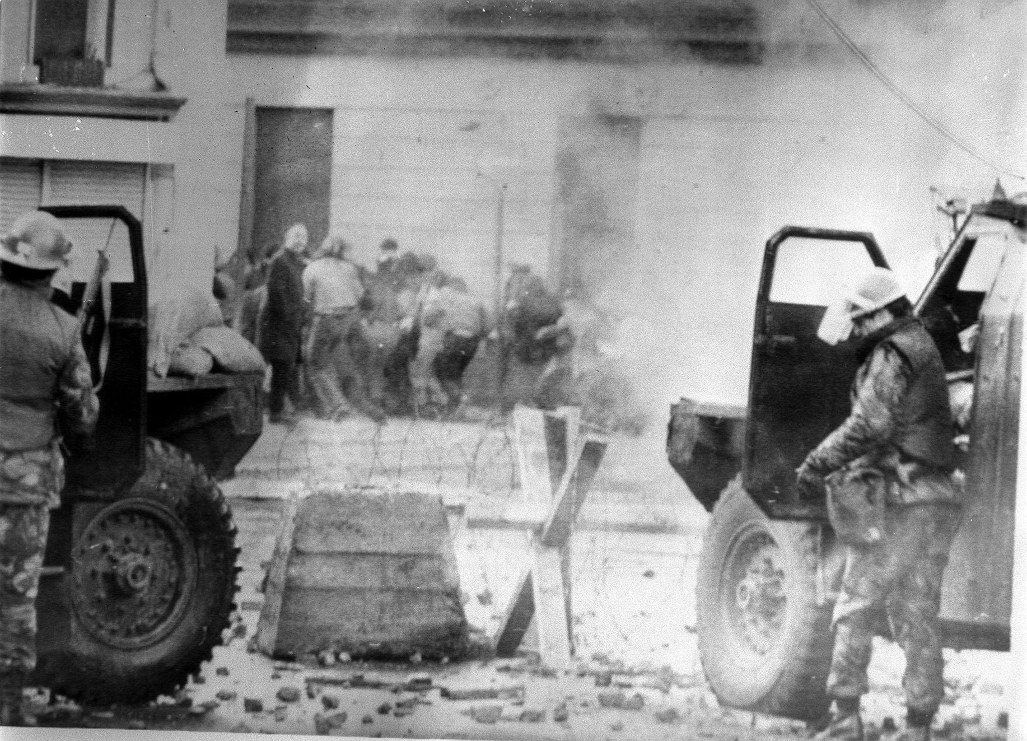 Soldiers taking cover behind armoured cars during the 1972 march