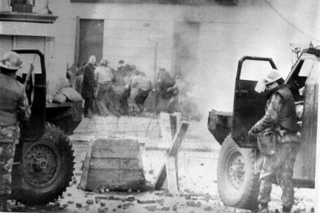 Soldiers taking cover behind armoured cars during the 1972 march