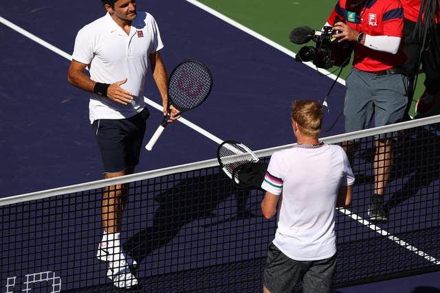 Roger Federer shakes hands at the net after his straight sets victory against Kyle Edmund