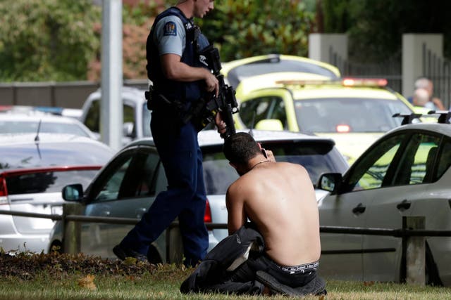 A man rests on the ground after the attack on a mosque in central Christchurch, New Zealand