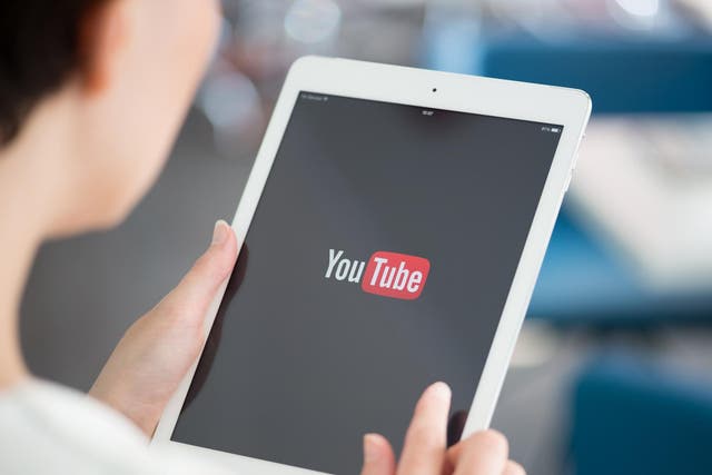 Woman holding a brand new Apple iPad Air with YouTube logo on a screen